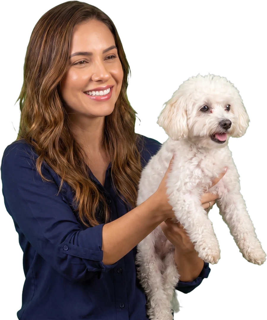 Dona de pet shop entregando um cachorro branco para a tutora no balcão